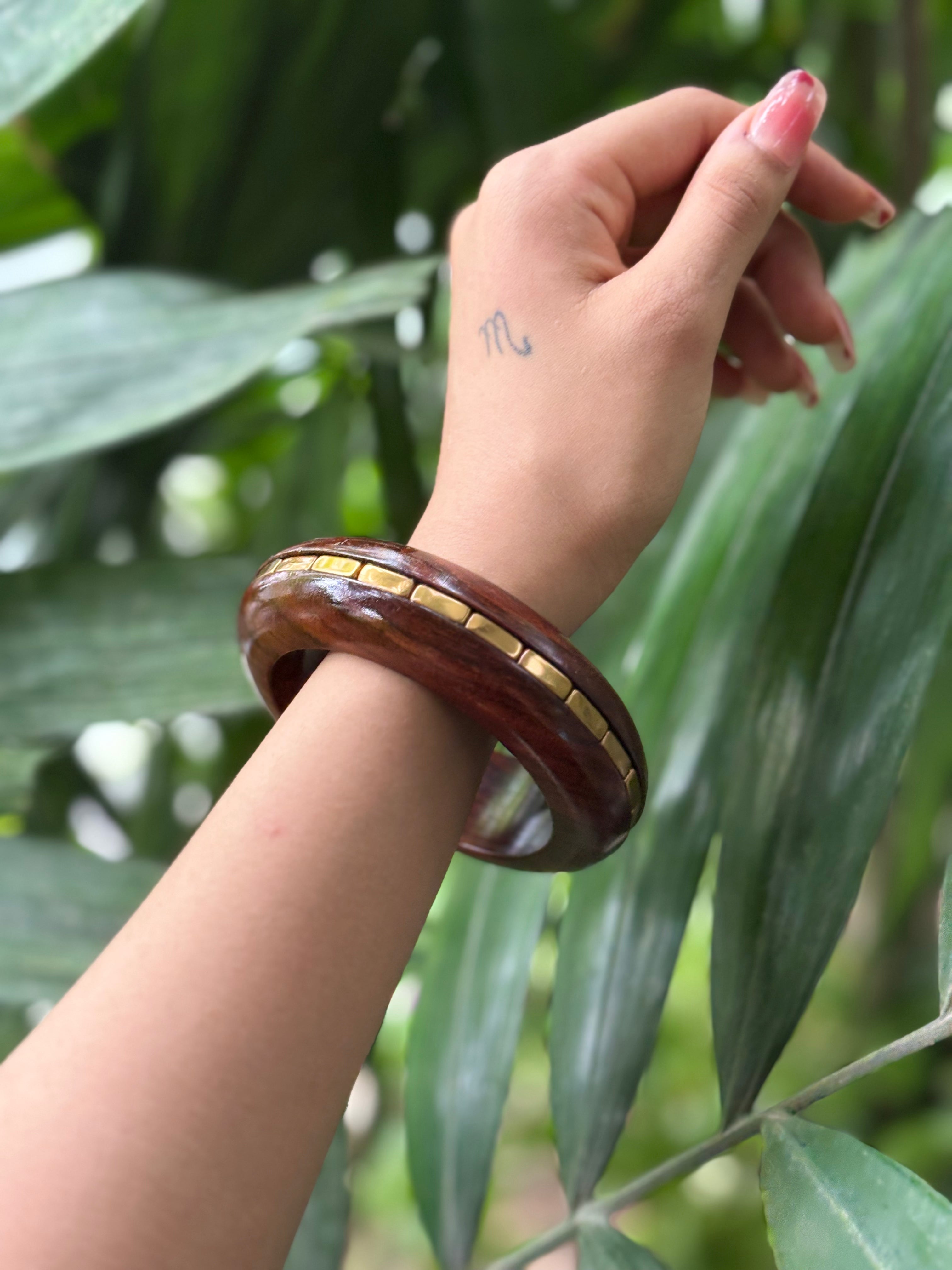 Close-up of gold inlay detail on wooden bangle set