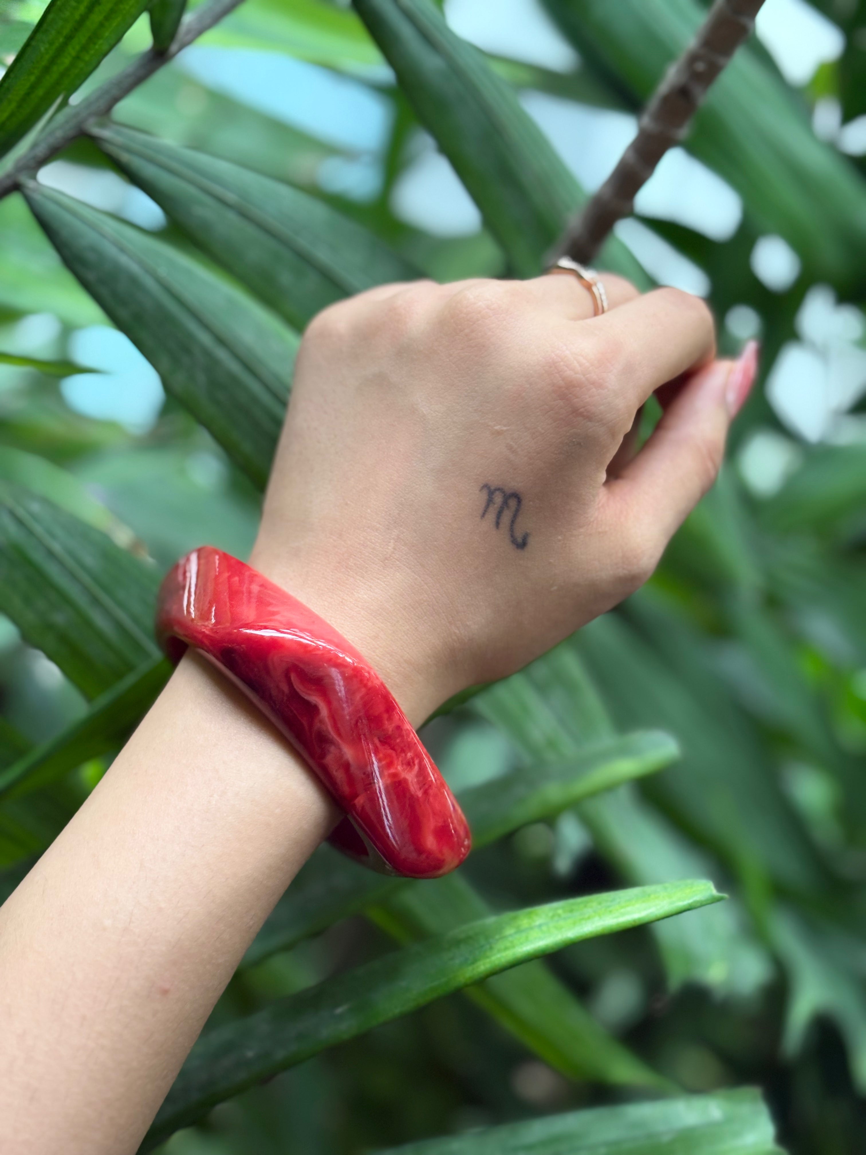 Close-up of red marbled resin bangle swirl